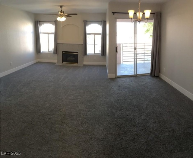 4555 E Sahara Ave Unit 226, Las Vegas, NV 89104 - unfurnished living room featuring baseboards, a chandelier, a ceiling fan, a tiled fireplace, and dark colored carpet