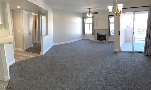 4555 E Sahara Ave Unit 226, Las Vegas, NV 89104 - unfurnished living room featuring light carpet, ceiling fan, a fireplace with flush hearth, baseboards, and a chandelier