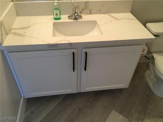 4555 E Sahara Ave Unit 226, Las Vegas, NV 89104 - bathroom featuring toilet, vanity, and wood finished floors
