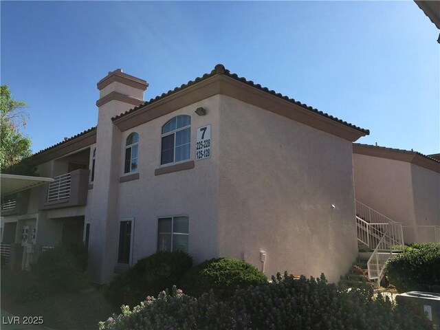 4555 E Sahara Ave Unit 226, Las Vegas, NV 89104 - view of property exterior featuring stucco siding, stairs, and a chimney