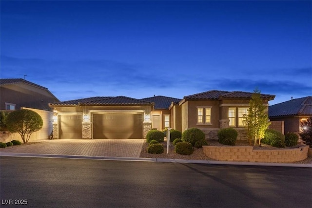 6192 Lautman Ridge Ct, Las Vegas, NV 89141 - mediterranean / spanish-style house with driveway, a tile roof, an attached garage, stucco siding, and stone siding
