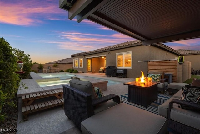 6192 Lautman Ridge Ct, Las Vegas, NV 89141 - patio terrace at dusk featuring a hot tub, a patio area, an outdoor living space with a fire pit, and an outdoor pool