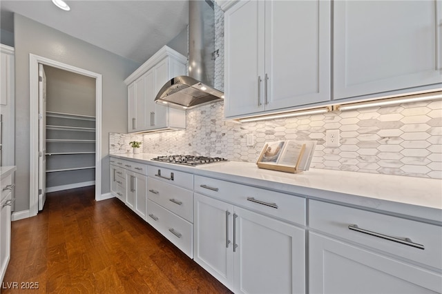 6192 Lautman Ridge Ct, Las Vegas, NV 89141 - kitchen featuring wall chimney exhaust hood, stainless steel gas stovetop, light countertops, white cabinets, and dark wood-style flooring