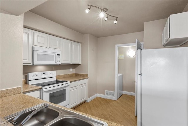 8000 Badura Ave Unit 2028, Las Vegas, NV 89113 - kitchen featuring white appliances, light wood-style flooring, white cabinets, and a sink