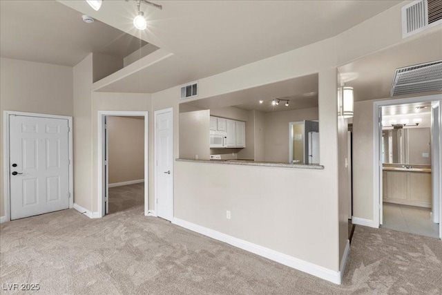 8000 Badura Ave Unit 2028, Las Vegas, NV 89113 - kitchen featuring carpet floors, white microwave, white cabinets, and baseboards