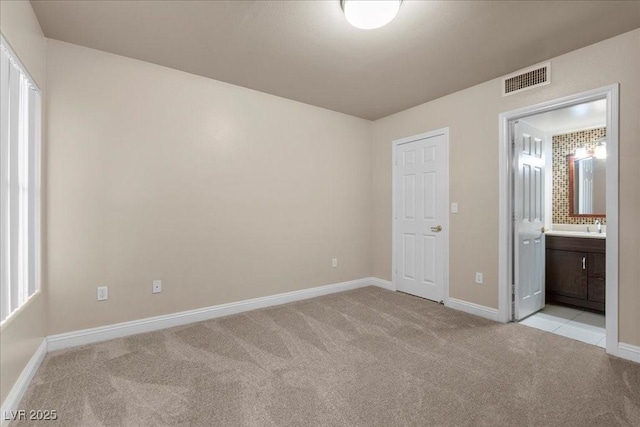 8000 Badura Ave Unit 2028, Las Vegas, NV 89113 - unfurnished bedroom with light carpet, baseboards, connected bathroom, and a sink
