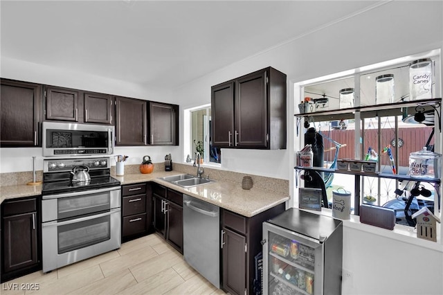 4419 Lorna Pl, Las Vegas, NV 89107 - kitchen featuring stainless steel appliances, a sink, dark brown cabinetry, light stone countertops, and wine cooler
