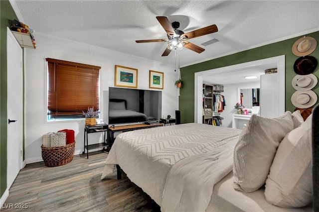 4419 Lorna Pl, Las Vegas, NV 89107 - bedroom with crown molding, wood finished floors, a textured ceiling, and ceiling fan