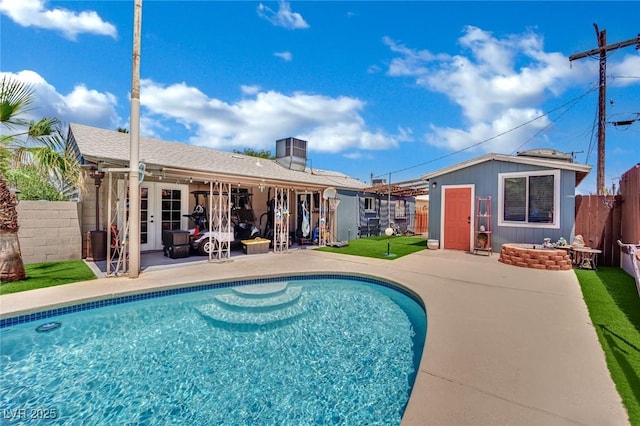 4419 Lorna Pl, Las Vegas, NV 89107 - view of swimming pool with a fenced backyard, an outdoor fire pit, a patio, french doors, and an outbuilding
