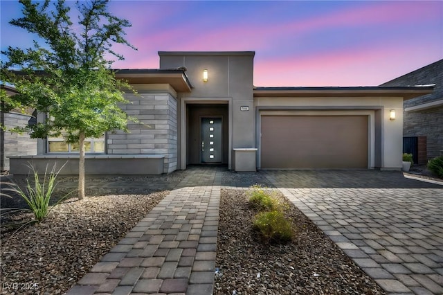 6684 Regency Stone Way, Las Vegas, NV 89148 - view of front facade with an attached garage, decorative driveway, stucco siding, and stone siding