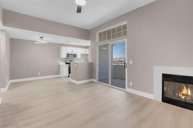 3150 Soft Breezes Dr Unit 2186, Las Vegas, NV 89128 - unfurnished living room featuring light wood-style floors, ceiling fan, baseboards, and a tiled fireplace