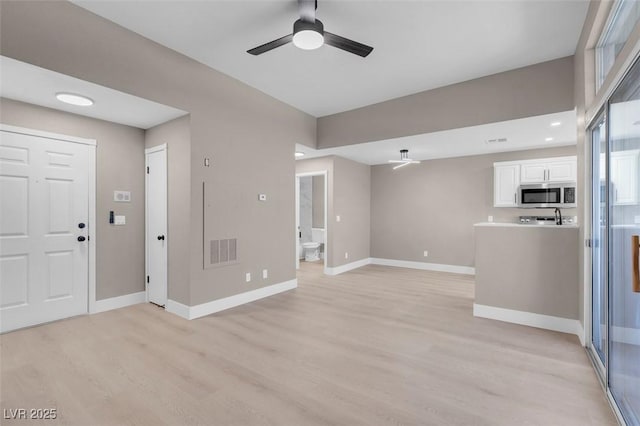 3150 Soft Breezes Dr Unit 2186, Las Vegas, NV 89128 - unfurnished living room featuring light wood-style flooring, baseboards, and ceiling fan