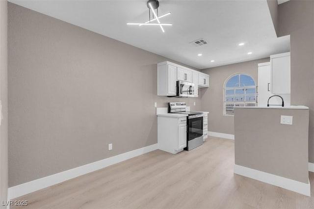 3150 Soft Breezes Dr Unit 2186, Las Vegas, NV 89128 - kitchen featuring appliances with stainless steel finishes, light wood-style flooring, baseboards, white cabinetry, and recessed lighting