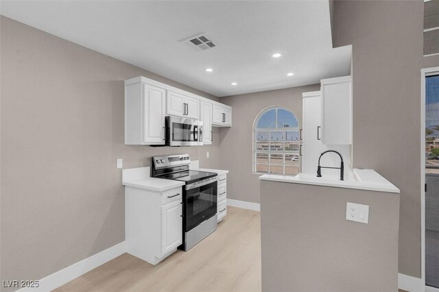 3150 Soft Breezes Dr Unit 2186, Las Vegas, NV 89128 - kitchen featuring appliances with stainless steel finishes, baseboards, light wood-type flooring, light countertops, and white cabinets