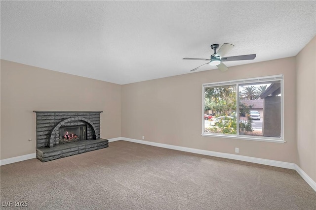 4431 El Campana Way, Las Vegas, NV 89121 - unfurnished living room with carpet flooring, a textured ceiling, ceiling fan, baseboards, and a stone fireplace