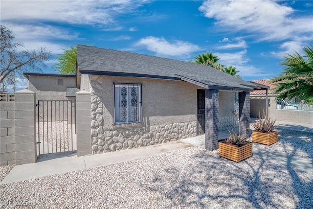 1608 E Mcdonald Ave, North Las Vegas, NV 89030 - view of front facade featuring a gate, a shingled roof, stucco siding, and a patio area