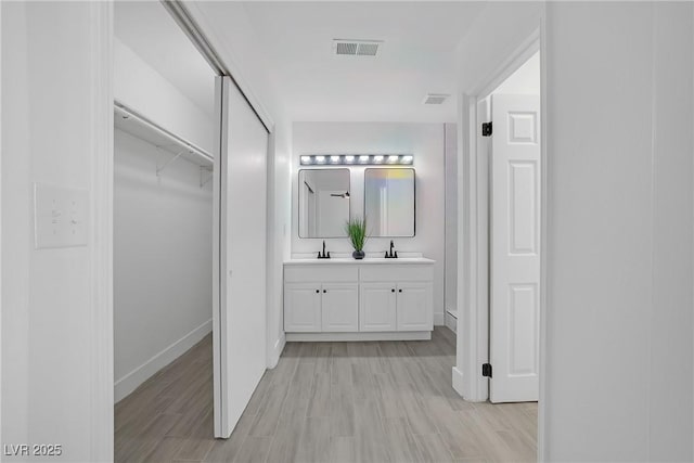 1608 E Mcdonald Ave, North Las Vegas, NV 89030 - bathroom with double vanity, wood finished floors, baseboards, and a spacious closet