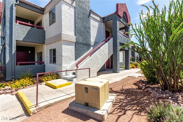 8600 W Charleston Blvd Unit 2085, Las Vegas, NV 89117 - view of side of home with stucco siding, a balcony, a tile roof, and a patio area