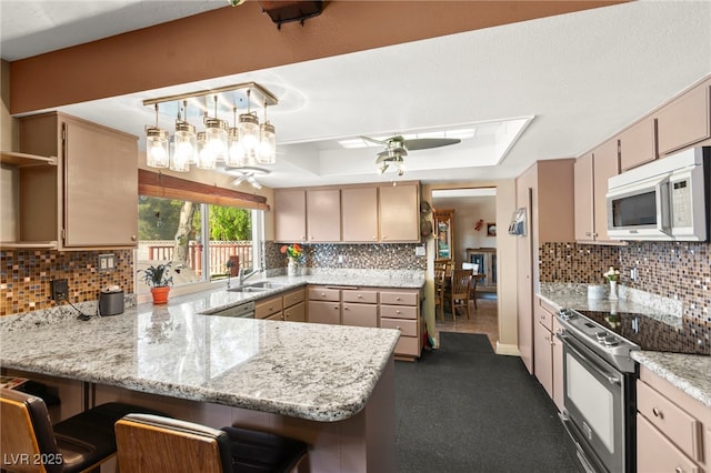 6612 Elton Ave, Las Vegas, NV 89107 - kitchen featuring white microwave, range with electric stovetop, a peninsula, a sink, and open shelves