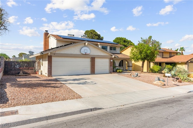 6612 Elton Ave, Las Vegas, NV 89107 - traditional-style home featuring a garage, a chimney, roof mounted solar panels, concrete driveway, and stucco siding