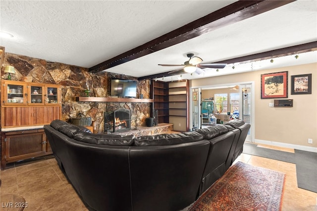 6612 Elton Ave, Las Vegas, NV 89107 - living room with a textured ceiling, a ceiling fan, beam ceiling, a fireplace, and light tile patterned floors