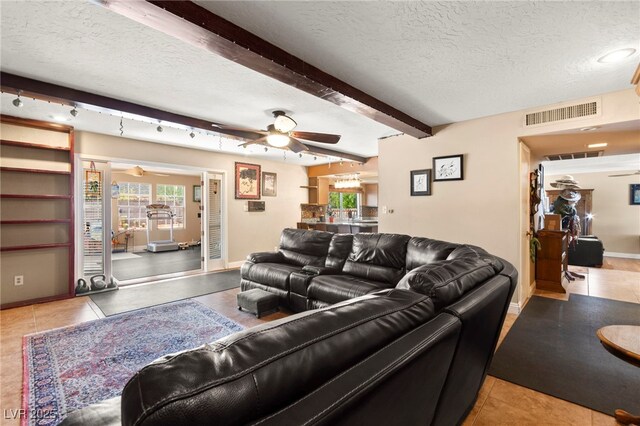 6612 Elton Ave, Las Vegas, NV 89107 - tiled living area featuring ceiling fan, a textured ceiling, beam ceiling, and baseboards