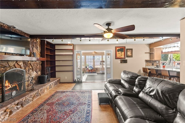 6612 Elton Ave, Las Vegas, NV 89107 - living area featuring plenty of natural light, ceiling fan, track lighting, a fireplace, and a textured ceiling
