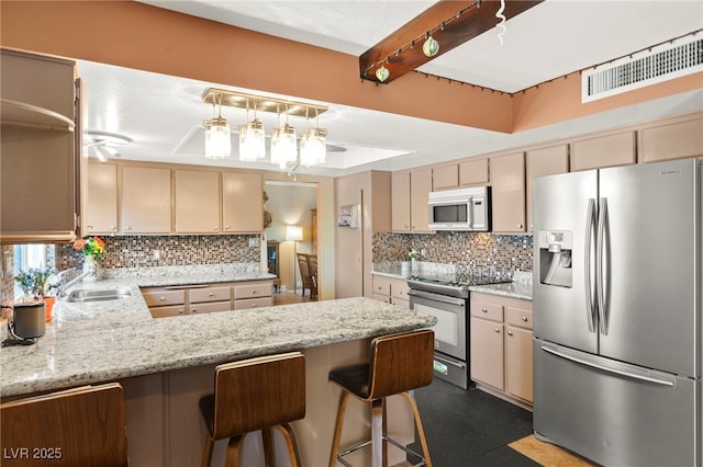 6612 Elton Ave, Las Vegas, NV 89107 - kitchen with stainless steel appliances, a sink, a peninsula, backsplash, and light stone countertops
