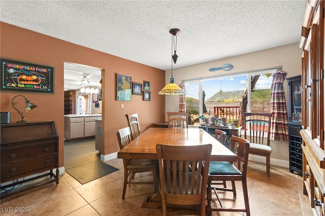 6612 Elton Ave, Las Vegas, NV 89107 - dining room featuring a textured ceiling, light tile patterned floors, and baseboards