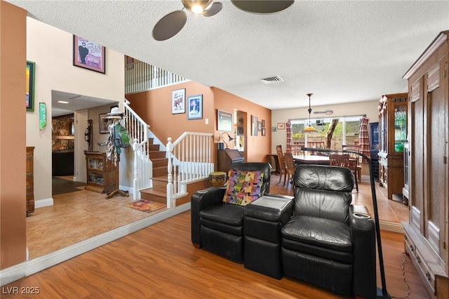 6612 Elton Ave, Las Vegas, NV 89107 - living room with ceiling fan, stairs, a textured ceiling, wood finished floors, and baseboards