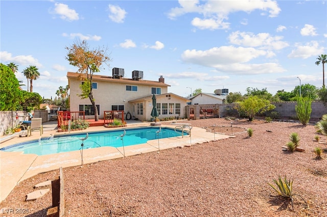 6612 Elton Ave, Las Vegas, NV 89107 - view of swimming pool featuring a wooden deck, a fenced backyard, central AC unit, and a patio area