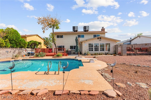 6612 Elton Ave, Las Vegas, NV 89107 - view of pool featuring a wooden deck, a fenced backyard, a diving board, central air condition unit, and a patio