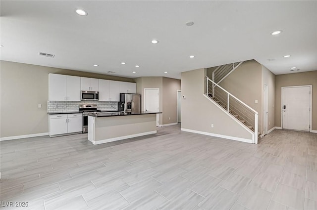 3760 Paseo De Paz Ave, Las Vegas, NV 89115 - kitchen with appliances with stainless steel finishes, open floor plan, dark countertops, baseboards, and backsplash