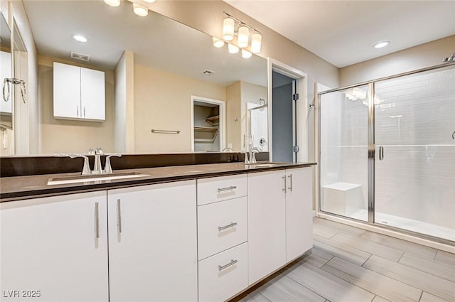 3760 Paseo De Paz Ave, Las Vegas, NV 89115 - bathroom with double vanity, a stall shower, a spacious closet, and recessed lighting