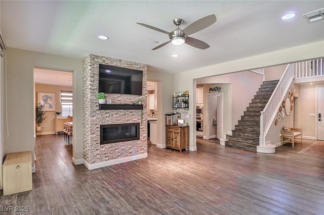 2497 Birch Hollow St, Henderson, NV 89044 - living room featuring a ceiling fan, wood finished floors, baseboards, stairs, and a stone fireplace