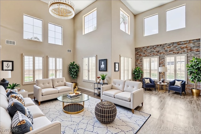 8113 Gothic Ave, Las Vegas, NV 89117 - living area with a towering ceiling, a chandelier, wood finished floors, and baseboards