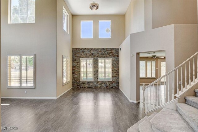 8113 Gothic Ave, Las Vegas, NV 89117 - foyer with a towering ceiling, wood finished floors, stairs, ceiling fan, and baseboards