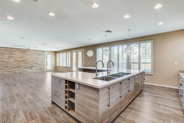 8113 Gothic Ave, Las Vegas, NV 89117 - kitchen featuring a sink, an island with sink, baseboards, light wood-style floors, and recessed lighting