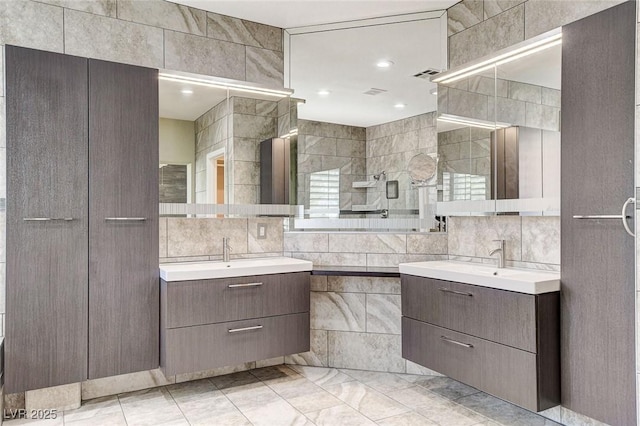 8113 Gothic Ave, Las Vegas, NV 89117 - bathroom featuring tile walls, two vanities, decorative backsplash, and tiled shower