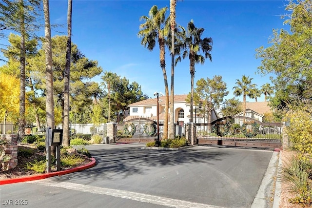 8113 Gothic Ave, Las Vegas, NV 89117 - view of asphalt road featuring a gate, curbs, and a gated entry