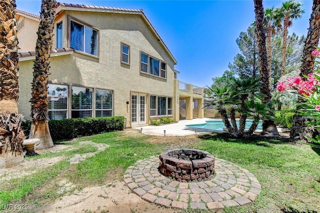 8113 Gothic Ave, Las Vegas, NV 89117 - rear view of house featuring a patio area, stucco siding, a fire pit, and a lawn