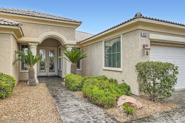 4311 Fiore Bella Blvd, Las Vegas, NV 89135 - doorway to property with french doors, stucco siding, an attached garage, and a tile roof