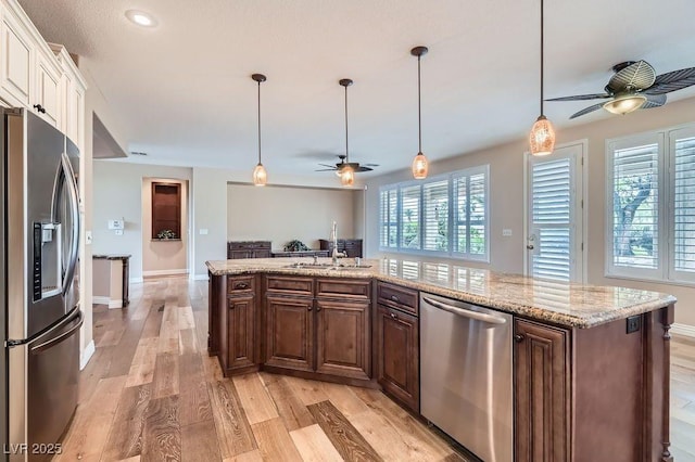 4311 Fiore Bella Blvd, Las Vegas, NV 89135 - kitchen with appliances with stainless steel finishes, ceiling fan, open floor plan, white cabinetry, and light wood finished floors