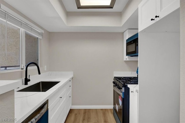 8070 W Russell Rd Unit 2052, Las Vegas, NV 89113 - kitchen with gas range, freestanding refrigerator, a sink, and white cabinetry
