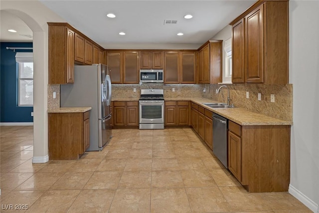 4225 Telstar Ct, North Las Vegas, NV 89032 - kitchen featuring stainless steel appliances, a sink, brown cabinetry, baseboards, and recessed lighting