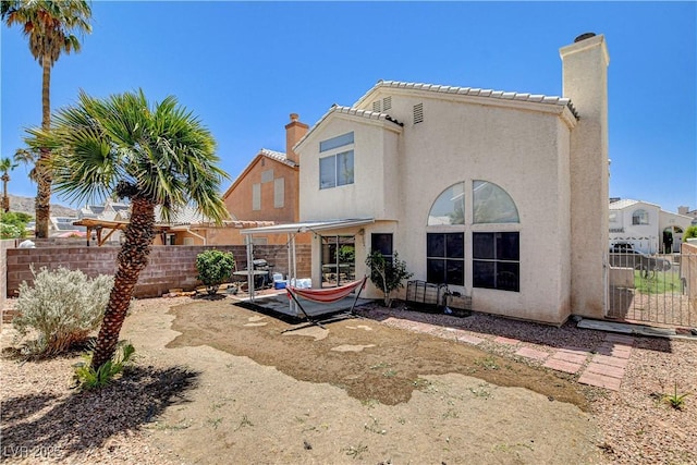 6058 Grape Blossom Ave, Las Vegas, NV 89142 - rear view of house featuring a chimney, stucco siding, a patio area, and a fenced backyard