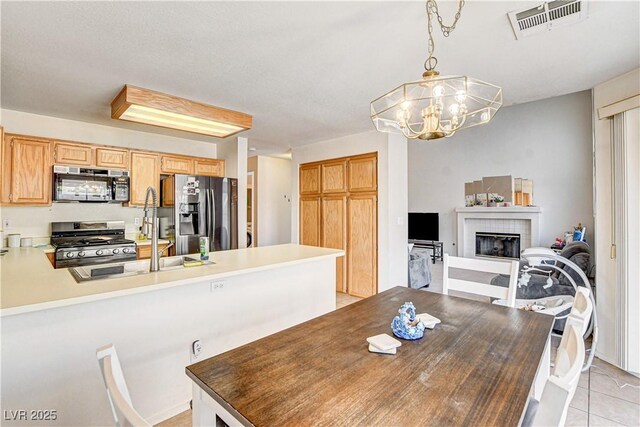 6058 Grape Blossom Ave, Las Vegas, NV 89142 - dining area featuring a chandelier, a tiled fireplace, and light tile patterned flooring