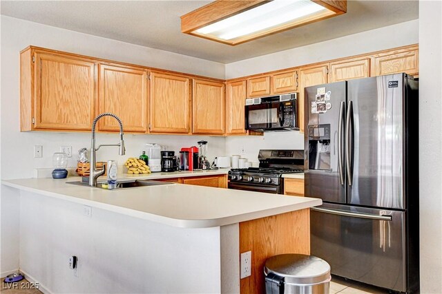 6058 Grape Blossom Ave, Las Vegas, NV 89142 - kitchen featuring black appliances, a peninsula, light countertops, and light tile patterned floors