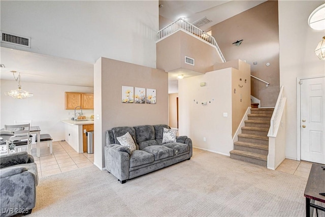 6058 Grape Blossom Ave, Las Vegas, NV 89142 - living area with a high ceiling, stairs, light colored carpet, light tile patterned flooring, and a chandelier