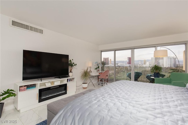 3111 Bel Air Dr Unit 12G, Las Vegas, NV 89109 - bedroom with access to outside, marble look tile flooring, and a glass covered fireplace